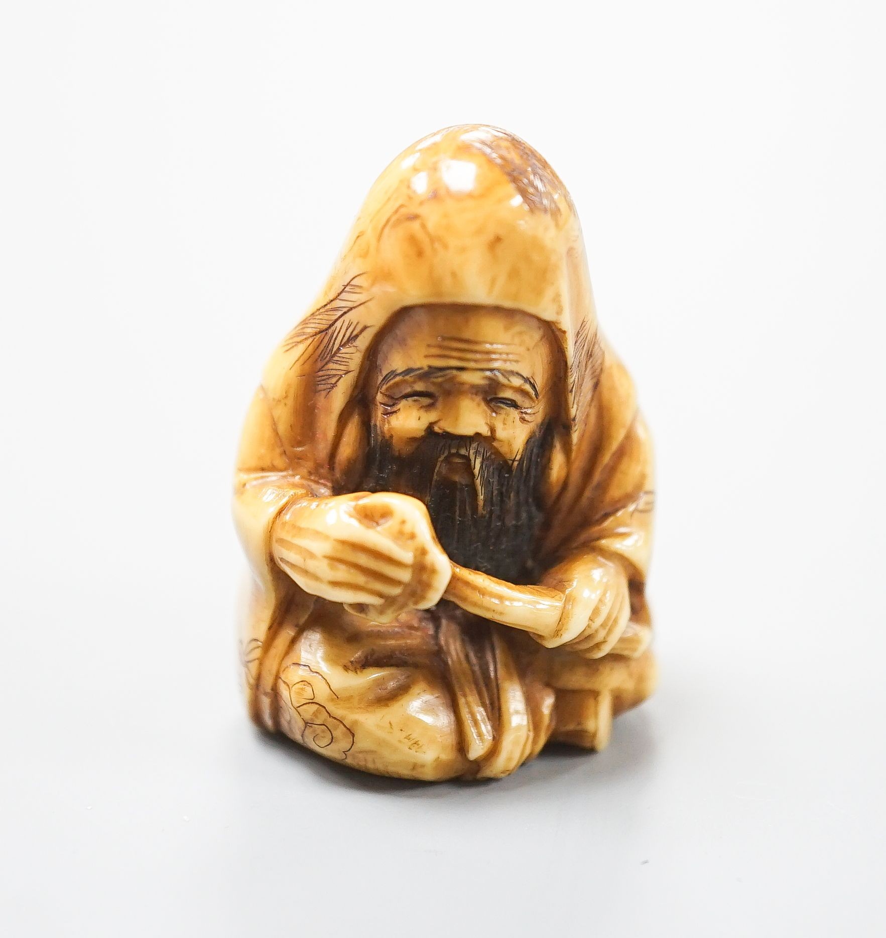 A Japanese ivory netsuke of Fukurokuju seated, holding a sceptre, early 20th century, 3.8cm